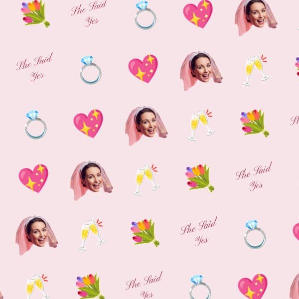 Blush pink wrapping paper with sparkling diamond rings, hearts, a smiling bride-to-be and flowing calligraphy