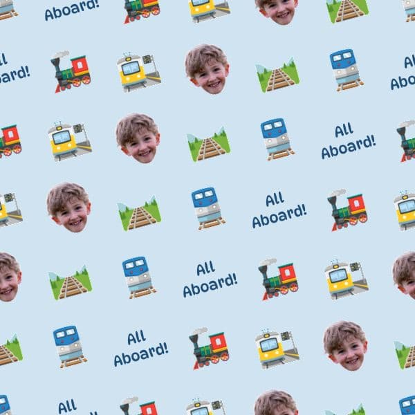 Wrapping paper with cartoon steam trains, stations and tracks in red, blue and yellow, with a child's photo and station name