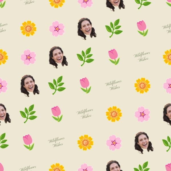 Wrapping paper with scattered sage and blush wildflowers around softly repeated initials