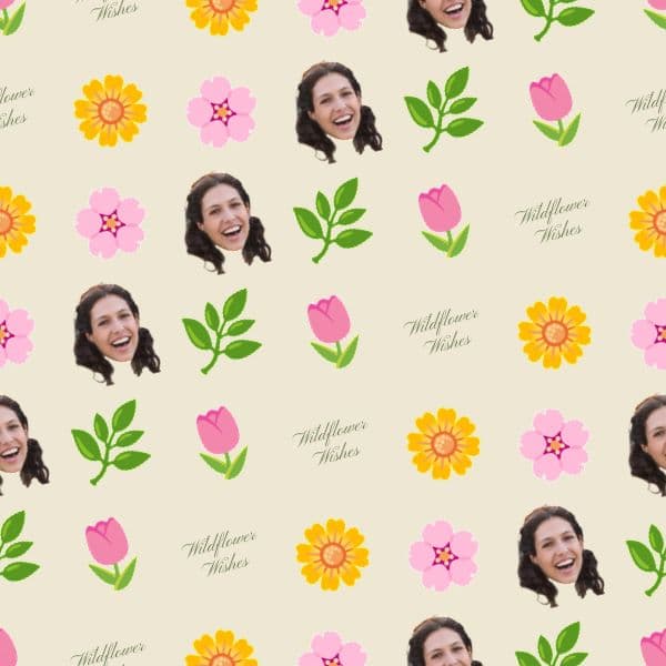 Wrapping paper with scattered sage and blush wildflowers around softly repeated initials